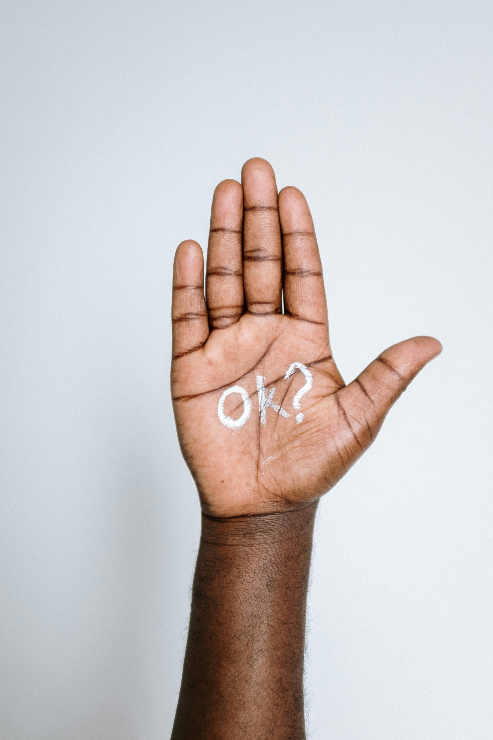 Une main de couleur tendue avec le signe OK dans la paume
